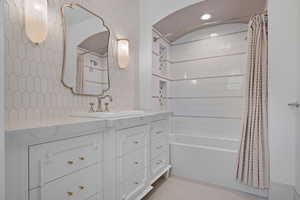 Bathroom with vanity, light tile patterned floors, and shower / bath combination with curtain