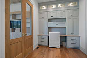 Unfurnished office featuring built in study area and dark wood finished floors