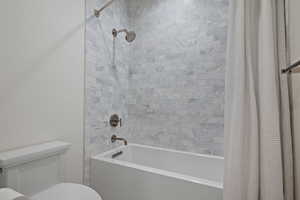 Full bath featuring shower / bath combo and toilet