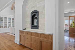 Bar area with brown cabinets, light wood-style flooring, and recessed lighting