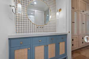 Half bath with vanity, dark wood-type flooring, and a closet