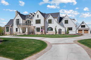View of front of property featuring board and batten siding, a front yard, and stone siding