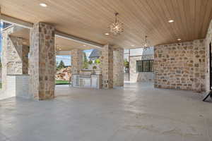 View of patio with area for grilling and an outdoor stone fireplace