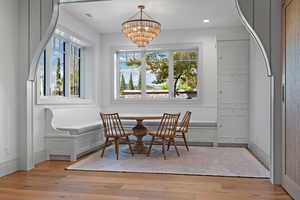 Dining room featuring breakfast area, light wood finished floors, recessed lighting, and a chandelier