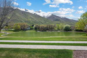 View of home's community with a water and mountain view and a yard