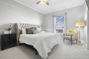Carpeted bedroom featuring ornamental molding and ceiling fan