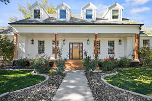 View of front of property featuring a front yard and a covered porch