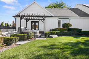 Back of house featuring board and batten siding, hot tub, and a shingled roof