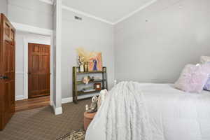 Bedroom with ornamental molding and carpet