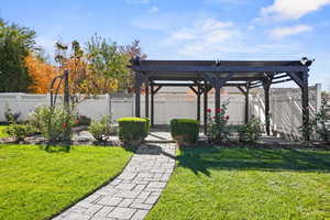 View of fenced backyard and pergola