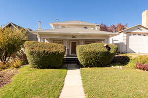 View of front of property with a porch and a front yard