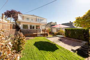 Rear view of house with a wooden deck and a patio area