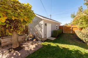 Fenced backyard featuring an outbuilding