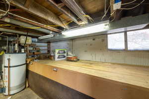 Below grade area featuring gas water heater and a workshop area