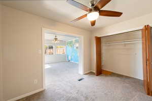 Unfurnished bedroom featuring carpet floors, a closet, and a ceiling fan