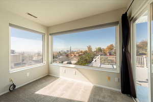 Unfurnished sunroom featuring carpet and a mountain view