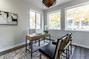 Office area featuring baseboards and dark wood-type flooring