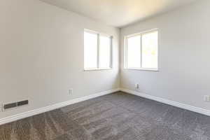 Spare room featuring carpet floors and baseboards