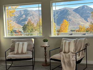 Sitting room with a mountain view and carpet flooring