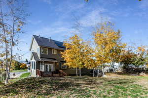 Back of property with a metal roof, solar panels, a standing seam roof, and a wooden deck