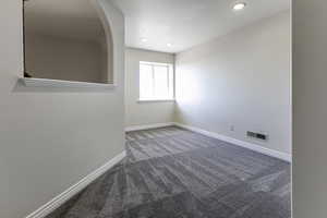 Carpeted empty room with recessed lighting