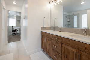 Full bathroom with recessed lighting, double vanity, light tile patterned floors, tasteful backsplash, and a shower stall