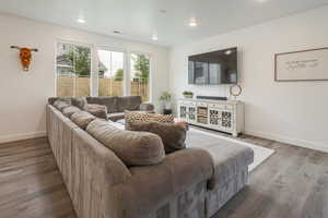 Living area with wood finished floors and recessed lighting