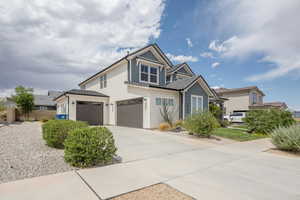 View of front facade with concrete driveway, stucco siding, and an attached garage