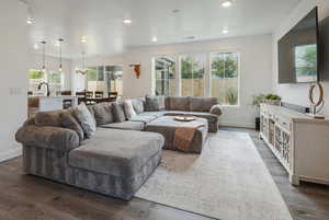 Living area featuring dark wood-style flooring, recessed lighting, a chandelier, and wine cooler