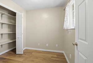 Unfurnished bedroom with light wood-style floors and a closet