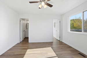 Unfurnished bedroom featuring light wood-type flooring, ceiling fan, and connected bathroom