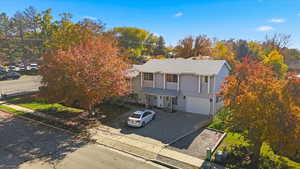Traditional-style house featuring a porch, driveway, and an attached garage
