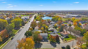Aerial view of property and surrounding area featuring nearby suburban area and a nearby body of water