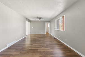 Spare room featuring a textured ceiling, wood finished floors, and a ceiling fan
