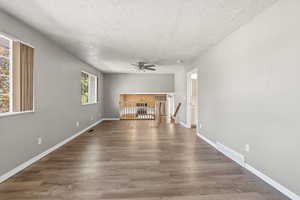 Unfurnished living room with a textured ceiling and wood finished floors