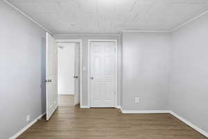 Unfurnished bedroom with wood finished floors and baseboards