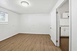 Unfurnished room with light wood finished floors and a textured ceiling