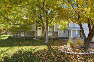 View of front of home featuring stone siding and a front yard