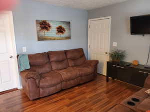 Living room with wood finished floors and a textured ceiling