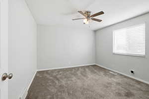 Spare room featuring carpet flooring and a ceiling fan