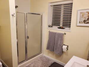 Bathroom featuring a shower stall and vanity