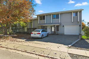 Traditional-style house with concrete driveway, an attached garage, and a porch