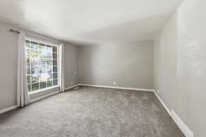 Spare room featuring light carpet and baseboards