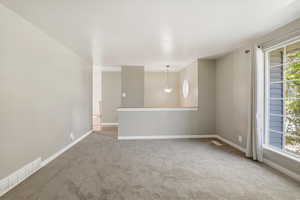 Empty room featuring light carpet and baseboards