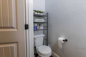 Bathroom with toilet and a textured wall