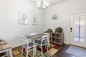 Dining area featuring dark wood finished floors and a chandelier