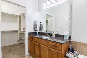 Full bathroom featuring vanity and a spacious closet