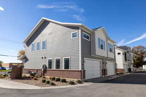 View of side of property with brick siding and a garage