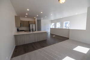 Kitchen featuring a peninsula, freestanding refrigerator, open floor plan, modern cabinets, and dark carpet