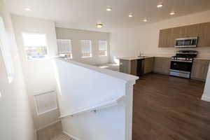 Kitchen with a peninsula, light countertops, stainless steel appliances, plenty of natural light, and recessed lighting